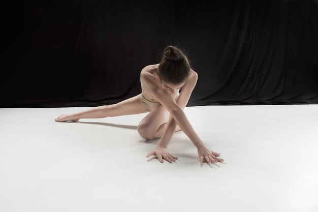 Joven bailarina adolescente bailando sobre fondo de estudio de piso blanco. Proyecto bailarina.