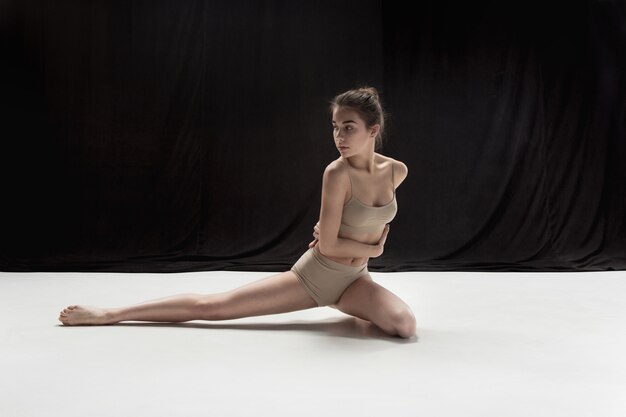 Joven bailarina adolescente bailando sobre fondo de estudio de piso blanco. Proyecto bailarina.