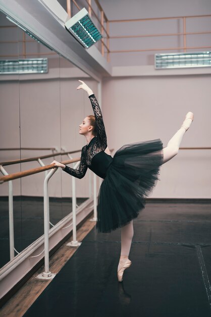 Joven bailarina de ballet clásico practicando en el estudio de baile