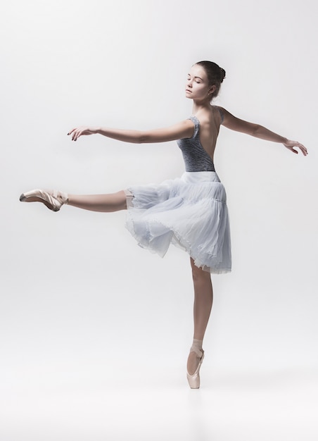 Joven bailarina clásica bailando en blanco