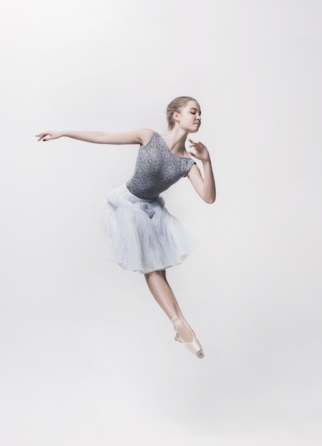 Joven bailarina clásica bailando sobre fondo blanco. Proyecto bailarina.