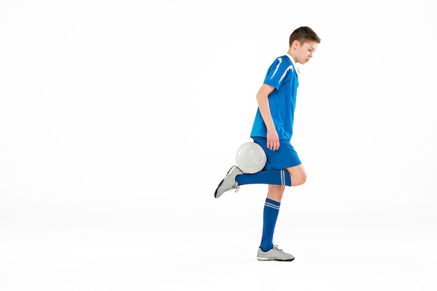 Joven con balón de fútbol haciendo patada voladora