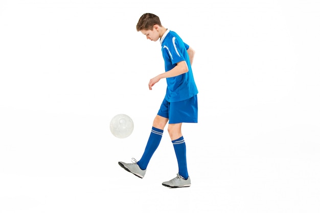 Joven con balón de fútbol haciendo patada voladora