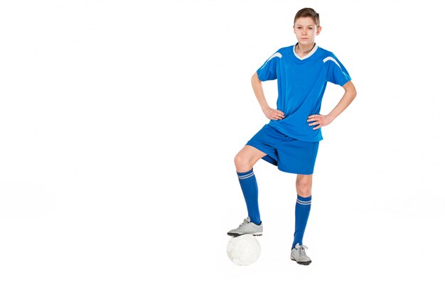 Joven con balón de fútbol haciendo patada voladora