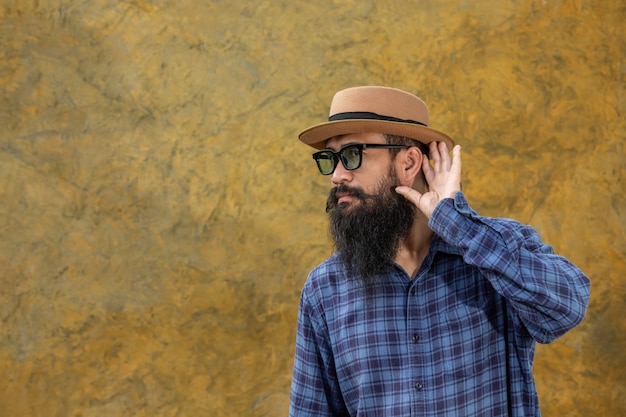 Joven con barba larga con sombrero y gafas