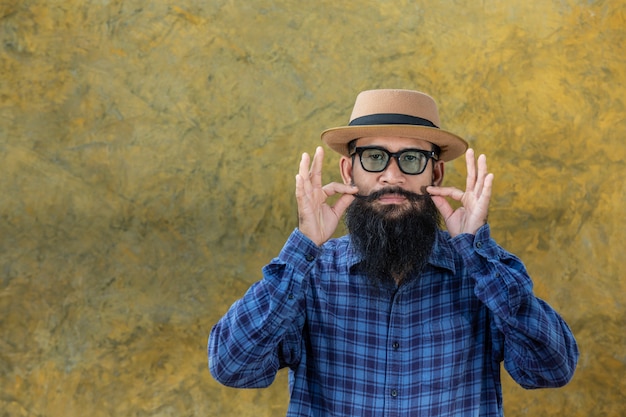 Joven con barba larga con sombrero y gafas