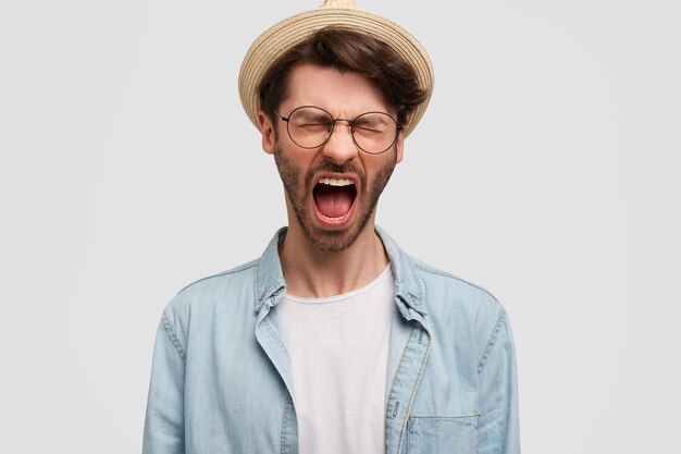 Joven barbudo con gafas redondas y camisa vaquera