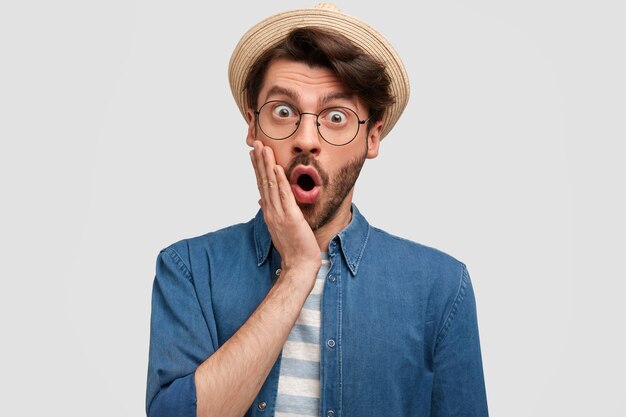 Joven barbudo con gafas redondas y camisa vaquera