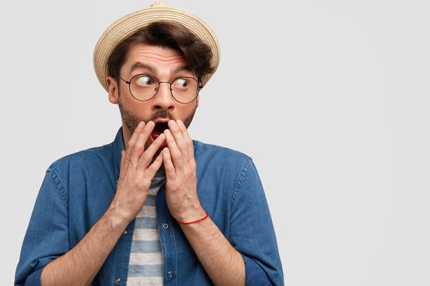 Joven barbudo con gafas redondas y camisa vaquera