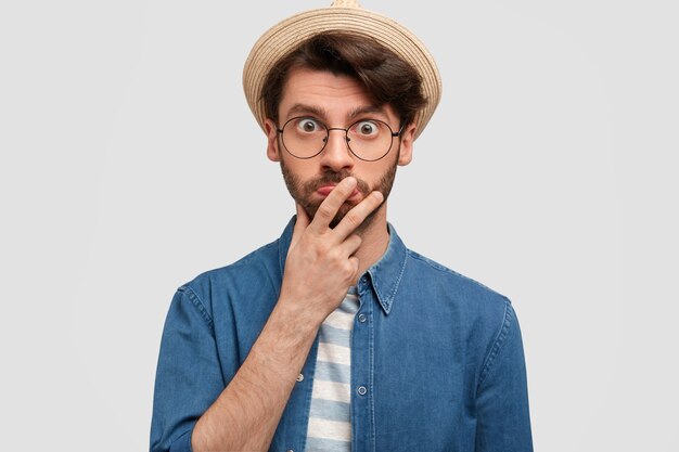 Joven barbudo con gafas redondas y camisa vaquera