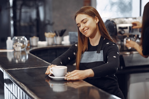 Joven barista hace café y sonríe