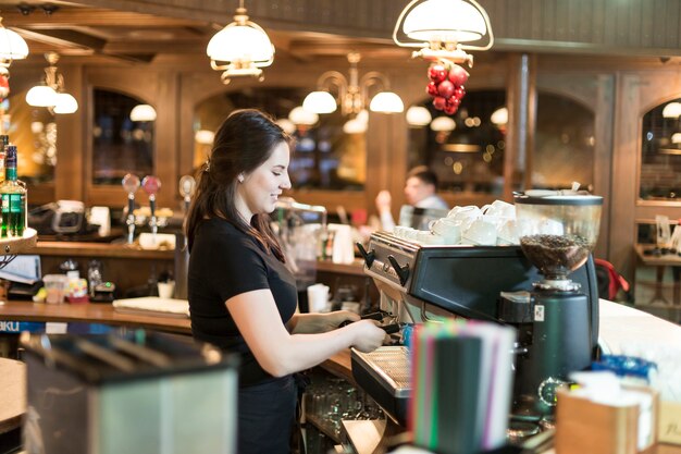 Joven barista haciendo café