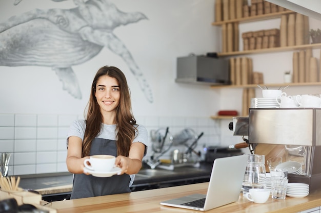 Joven barista sirviendo el mejor capuchino del mundo