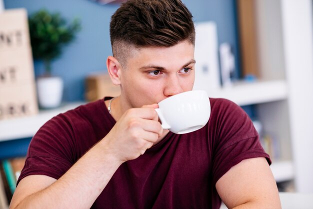 Joven bebiendo de la taza