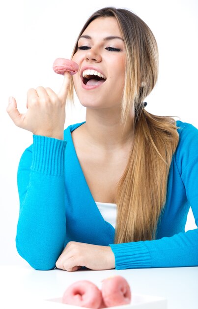 Joven y bella muchacha comer donut. Aislado en blanco.