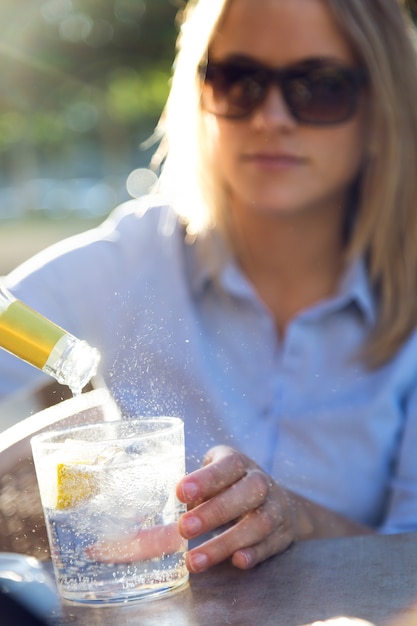 Foto gratuita joven y bella mujer beber soda en una terraza del restaurante.