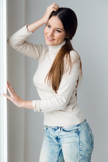 Joven y bella mujer en casa.