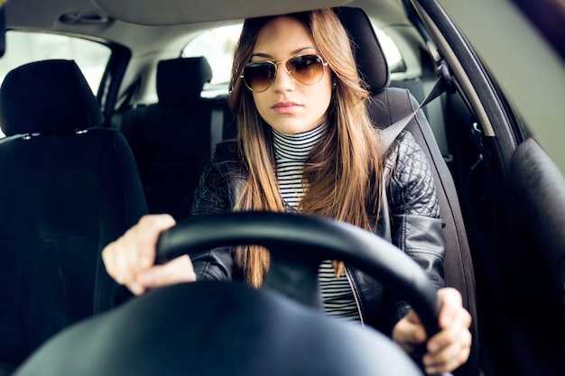 Foto gratuita joven y bella mujer conduciendo su coche.