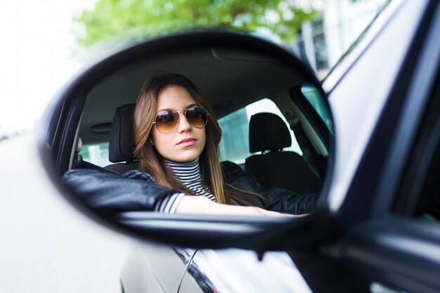 Joven y bella mujer conduciendo su coche.