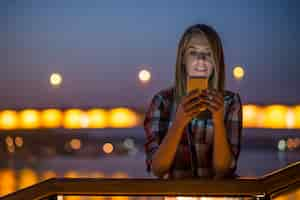 Foto gratuita joven y bella mujer hablando por teléfono móvil en la ciudad de la noche.