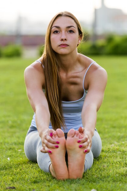 Joven y bella mujer haciendo yoga en la calle.