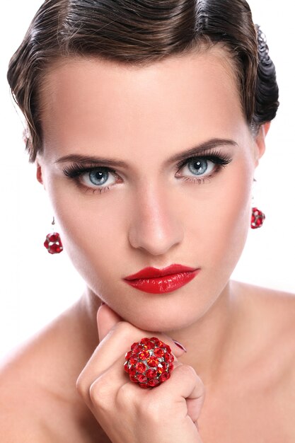 Joven y bella mujer con joyas rojas