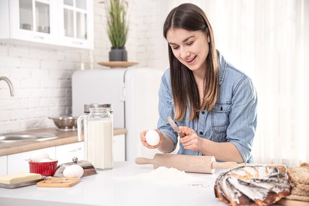 Una joven y bella mujer prepara pasteles caseros en la cocina. El concepto de nutrición casera saludable adecuada.