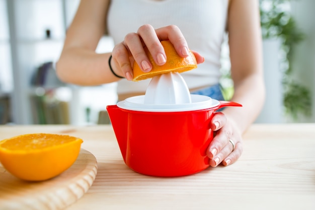 Joven y bella mujer preparando el desayuno en casa.