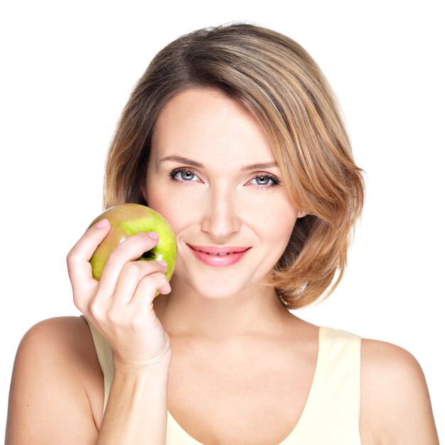 Joven y bella mujer sonriente toca la manzana para hacer frente a aislado en blanco.