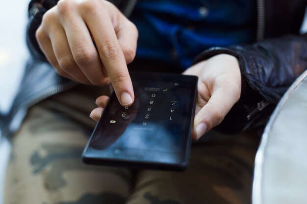 Joven y bella mujer utilizando su teléfono móvil en la calle.