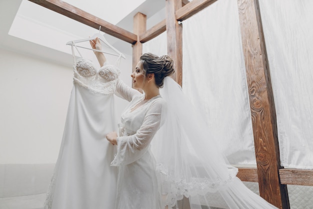 Foto gratuita una joven y bella novia en casa va a una boda