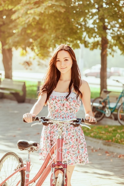 La joven con bicicleta en el parque