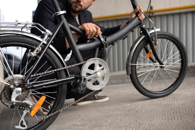 Joven con una bicicleta plegable en la ciudad