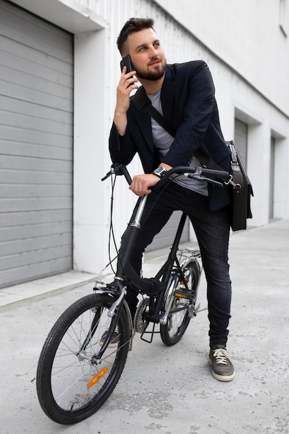 Joven con una bicicleta plegable en la ciudad