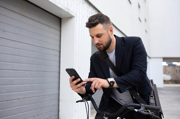 Joven con una bicicleta plegable en la ciudad