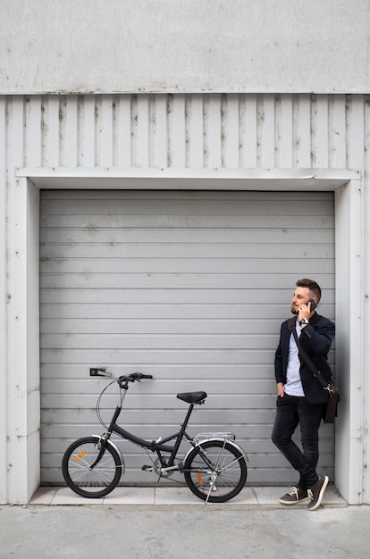 Joven con una bicicleta plegable en la ciudad