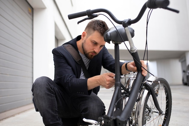 Joven con una bicicleta plegable en la ciudad