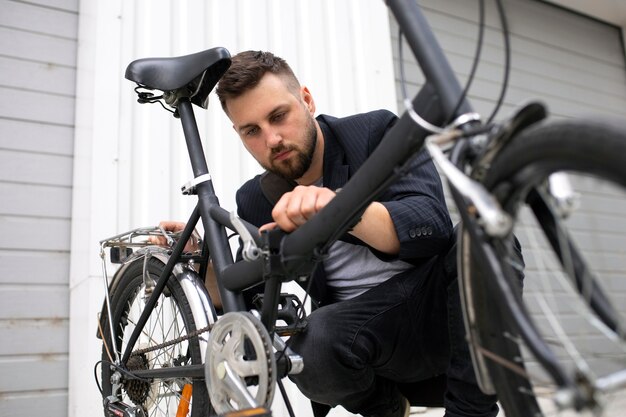 Joven con una bicicleta plegable en la ciudad