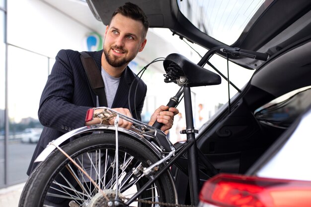 Joven con una bicicleta plegable en la ciudad