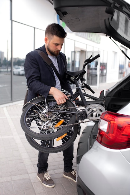 Joven con una bicicleta plegable en la ciudad