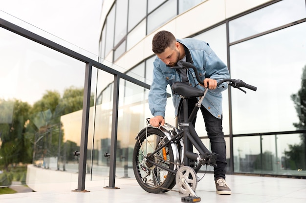 Joven con una bicicleta plegable en la ciudad