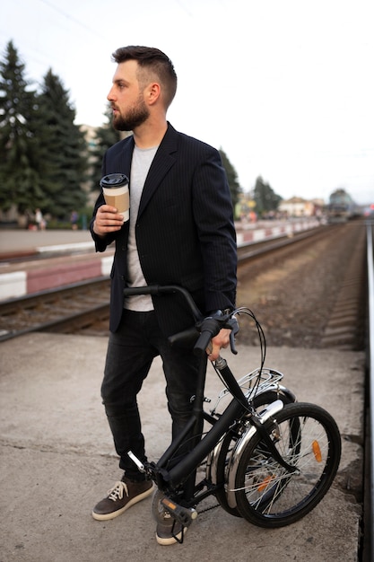 Foto gratuita joven con una bicicleta plegable en la ciudad