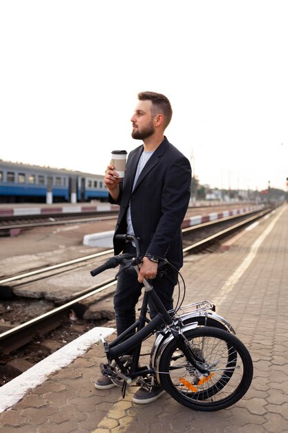 Joven con una bicicleta plegable en la ciudad