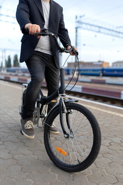 Joven con una bicicleta plegable en la ciudad