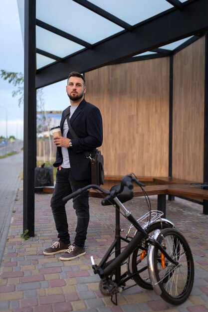 Foto gratuita joven con una bicicleta plegable en la ciudad