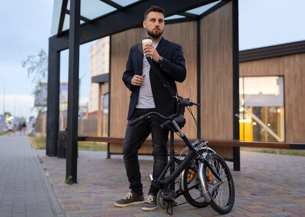 Joven con una bicicleta plegable en la ciudad