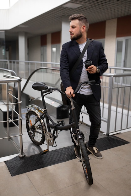 Joven con bicicleta plegable en escalera mecánica