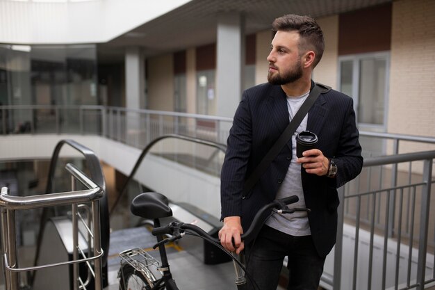 Joven con bicicleta plegable en escalera mecánica