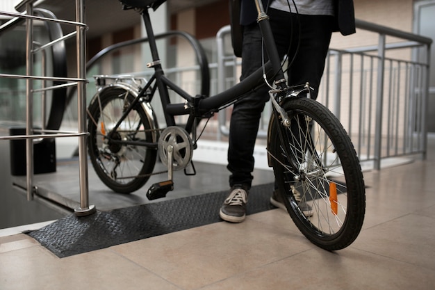 Foto gratuita joven con bicicleta plegable en escalera mecánica