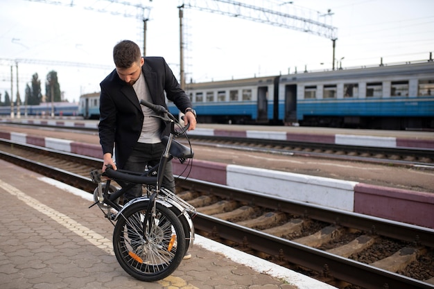 Foto gratuita joven con una bicicleta plegable mientras viaja en tren